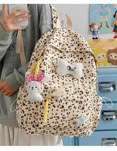 Leopard print school backpack detail showing cute plush bunny and star pendants for girls.