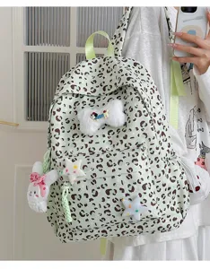 Green leopard print backpack with cute plush rabbit and bone charms, stylish student schoolbag.