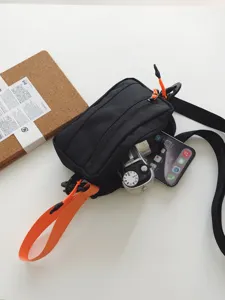 Trendy black tactical crossbody bag with orange accents, lightweight casual sling bag.
