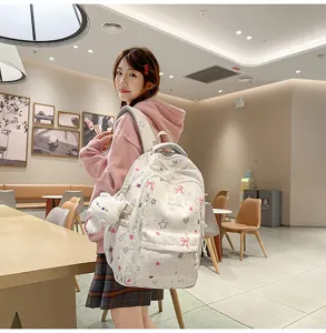 Cute school backpack detail view showing bow and star patterns, travel daypack for students.