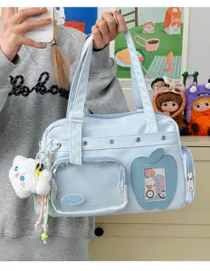 Detail shot of light blue ita bag featuring a clear front window and cute apple shaped card pocket.