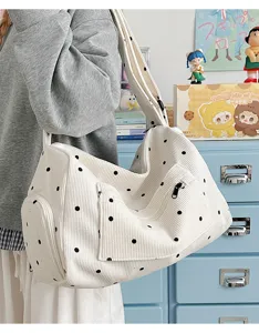 Detailed view of white corduroy polka dot shoulder bag, casual literary style messenger bag.
