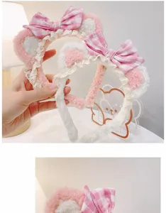 Close-up detail of plush cat ear headband with pink plaid bow and delicate lace trim.