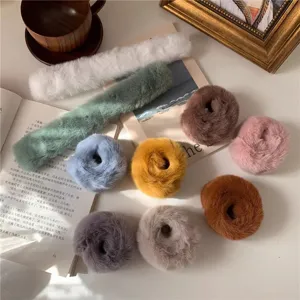 Zachte pluche haarelastiekjes en slap-armbanden in diverse gezellige kleuren, detail.
