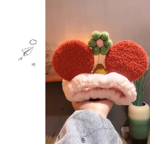 Cute red plush facial headband with mouse ears and flower decor for makeup and daily skincare.
