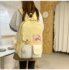 Detail view of cute yellow canvas backpack with multiple pockets and cute badges for students.