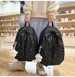 Detailed view of the cute star pattern black school backpack, featuring front pocket and charm.