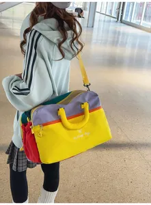 Λεπτομέρεια τσάντας ταξιδιού color-block, πολύχρωμο σχέδιο, ανθεκτικές λαβές, κέντημα.