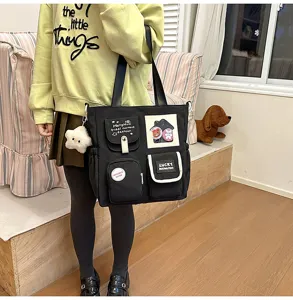 Black canvas tote bag with multiple pockets, cute patches and shoulder strap for daily use.