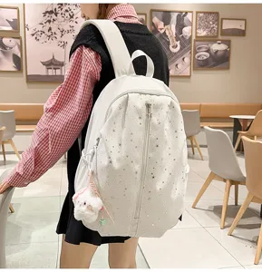 Stylish white star print backpack for women, cute casual school bag with plush pendant detail.