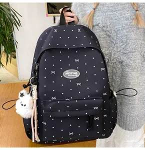 Detail view of Japanese minimalist backpack with bow pattern and cute pendant for daily use.