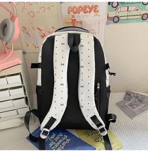 Detailed view of canvas backpack showing back straps with cute bow pattern in room setup.