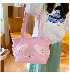 Cute pink corduroy tote bag detail, featuring plush bunny ears and glasses embroidery.