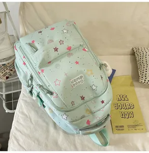 Close-up detail view of the light green cute student backpack featuring star and mushroom print.