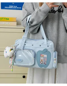 Detail view of light blue Japanese itabag with transparent display pocket and cute plush charm.