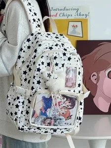 Detailed view of white star print ita bag with transparent window, badges, and cute plush charm.