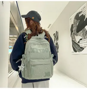 Detailed shot of the light green star pattern student backpack in a modern hallway setting.
