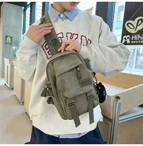 Detail view of a tactical casual sling backpack in army green with front pocket and straps.