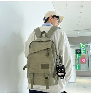 Detail shot of the camo green backpack showing daily styling and cute black cat plush pendant.