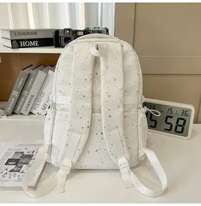 Detailed view of white star print backpack, casual school bag with adjustable straps and pockets.