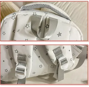 Close-up detail shot of the white school backpack with adjustable straps and cute star print.