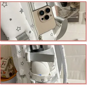 Detail shot of white star print school backpack pocket and side bottle strap feature.