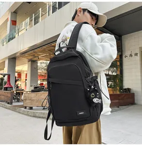 Minimalist black backpack detail featuring water-resistant fabric and cute cat plush pendant.