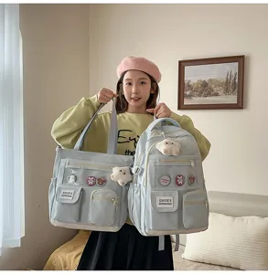 Detailed view of cute light blue student backpack and tote bag set with lovely badges and charms.