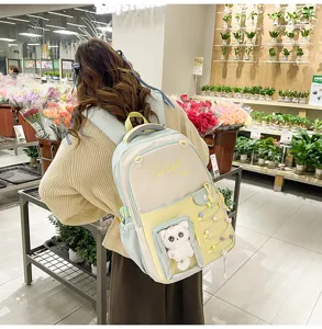 Color-blocked student ita backpack with transparent window, cute cat plush and braided rope details.