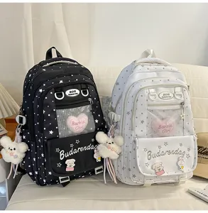 Sweet star pattern student backpack detail view with cute plush bear keychain and mesh pocket.