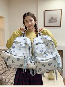 Detailed shot of cute sweet girl travel backpack with blue polka dots and plush pendant.