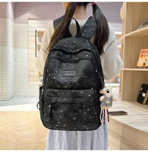 Vista dettagliata dello zaino scolastico con stampa di stelle e un grazioso ciondolo orsetto.