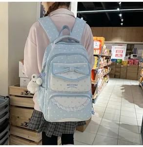 Joli sac à dos bleu clair à pois avec nœud et dentelle, idéal pour l'école et le quotidien.
