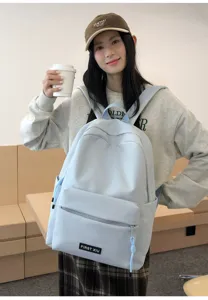 Sac à dos scolaire minimaliste bleu clair pour étudiants, avec tissu léger et poche avant.