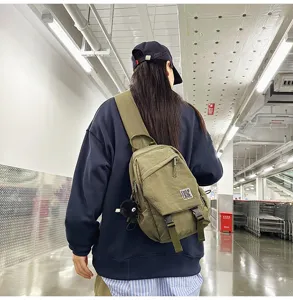 Casual canvas crossbody chest bag for men and women with front pocket and N-logo patch.