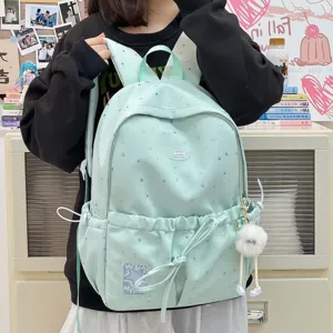 Detail view of the cute star print student backpack with cute rabbit ears and a pom-pom charm.