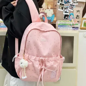 Pink cute star pattern school backpack detail showcasing soft fabric, plush pendant and pocket.