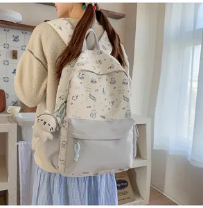 Close-up detail of the cute cat cartoon print backpack, showing fabric and front pocket.