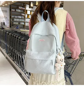 Light blue polka dot backpack for women, casual cute school bag with front pocket and cute bear pendant.