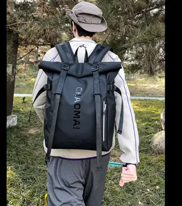 Outdoor black backpack detail view showing roll-top design, sturdy straps and functional pockets.