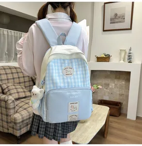 Cute blue plaid school backpack detail showing front pocket and lovely bear pendant.