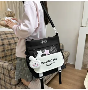 Stylish color block student canvas shoulder bag with clear window and cute plush bunny decor.