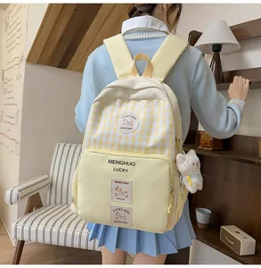 Detail shot of the cute yellow plaid school backpack, showing back wear and front pockets.