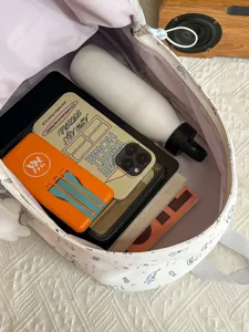 White canvas backpack with cute cartoon cat doodles, large capacity open main compartment.