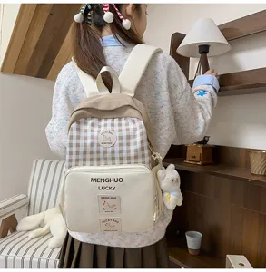 Detail view of brown plaid school backpack with front pocket, casual daily wear style.