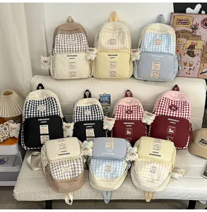 Detailed view of colorful grid school backpacks with cute bear pendants and front pocket designs.