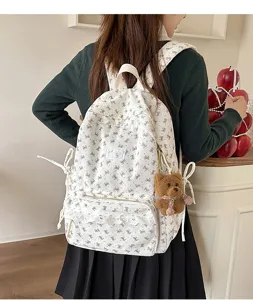 Korean style white corduroy backpack with cute bow prints and plush bear pendant for daily use.