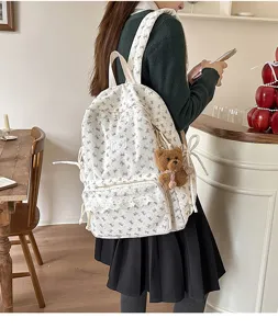 Korean ins style white corduroy backpack with cute bow prints and plush bear pendant for daily school use.