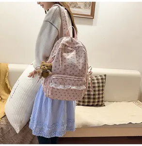 Pink corduroy bow school backpack detail showing cute lace trim and teddy bear pendant design.
