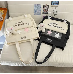 Vue détaillée du sac à bandoulière en toile coréenne avec porte-clés en peluche et poche transparente.